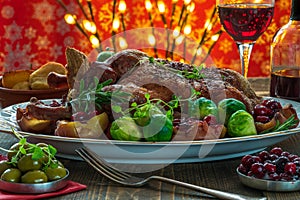 Festive roast duck on wooden table with brussel sprouts, baked p