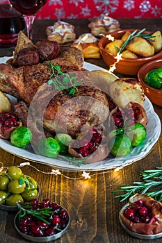 Festive roast duck on wooden table with brussel sprouts, baked p