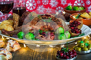 Festive roast duck on wooden table with brussel sprouts, baked p