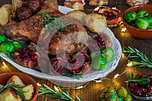 Festive roast duck on wooden table with brussel sprouts, baked p