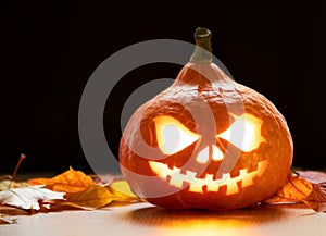 Festive scary halloween pumpkin on leaves on dark background