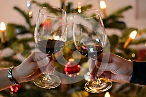 Festive scene of two people celebrating the holidays by toasting each other with glasses of wine
