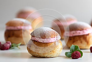 Festive Semlor or Semla : Traditional Scandinavian Buns flavored with cardamom filled with almond paste & raspberry whipped cream