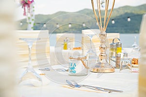 Festive serving table on the beach in sunny day. Preparing for an open-air party in the beach