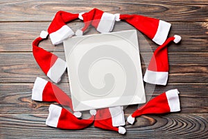 Festive set of plate decorated with Santa Claus hat on wooden background. Top view christmas dinner concept