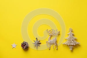 Festive silver dear, stars, fir-tree, cone on yellow background with copy space. Christmas and new year party. Minimal concept.