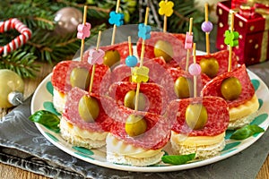 Festive snack of canapes on the Christmas table. Canapes with bread, cheese, salami.