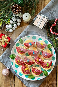 Festive snack of canapes on the Christmas table. Canapes with bread, cheese, salami and olives. Top view flat lay.