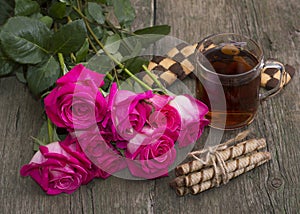 Festive still life from flowers, cookies and tea on a wooden table