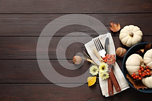 Festive table setting with autumn decor and space for text on wooden background, flat lay. Thanksgiving Day celebration