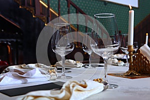 Festive table setting. Christmas or New Year. Candles on the table. Napkin rings. Photo in the interior. Out of focus. Without