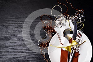 Festive table setting for christmas or new year dinner: vintage fork, spoon,knife on red napkin and christmas decorations on black