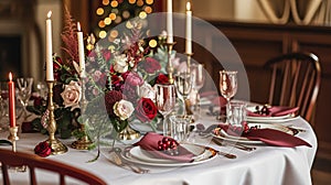 Festive table setting with cutlery, candles and beautiful red flowers in vase