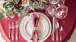 Festive table setting with cutlery, candles and beautiful red flowers in vase