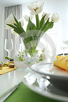 Festive table setting with Easter decorative eggs in bowl and tulips