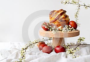 Festive table setting, Easter pastries on a wooden stand and cherry blossoms. Easter holiday concept.