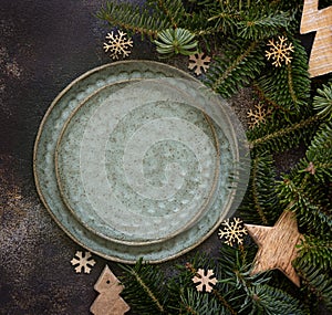 Festive table setting with fir tree branches and Rustic Christmas decorations on dark table top view