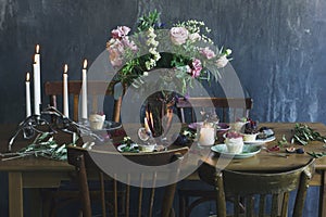 The festive table setting with flower bouquet, candles and dess