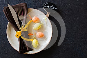 Festive table setting for holiday Easter dinner on dark table.