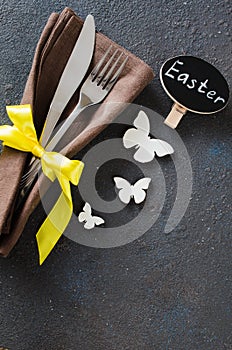 Festive table setting for holiday Easter dinner on dark table.