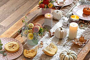 Festive table setting with pumpkins and chrysanthemum flowers.