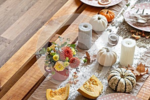 Festive table setting with pumpkins and chrysanthemum flowers.