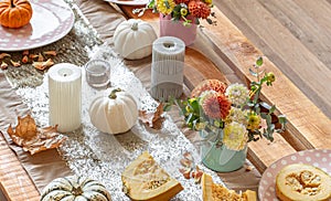 Festive table setting with pumpkins and chrysanthemum flowers.