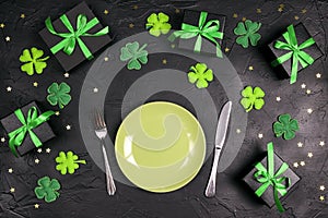 Festive table setting for St.Patrick`s day with cutlery and lucky symbols on black table