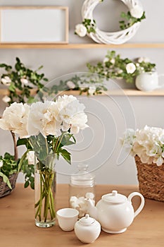 Festive table setting. Tea set and flowers on table. Bouquet of roses and peonies. Mother`s day greeting card. Happy Birthday!