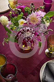 Festive table setting for Thanksgiving day. Autumnal decorations,plates, multicolor glasses and beautiful garden flowers