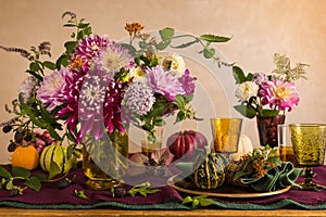 Festive table setting for Thanksgiving day. Autumnal decorations,plates, multicolor glasses and beautiful garden flowers