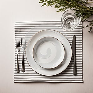 Festive table setting with white classic plate, cutlery set and fresh eucalyptus leaves on dark stone table and napkin. Top view