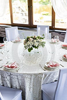 Festive table setting with wine glasses, and fresh flowers