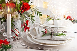 Festive table setting with winter flower arrangement on table decorated for holiday. Christmas or New Year dinner concept..