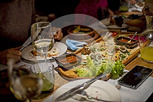 Festive table with wine and mixed meat with salad and sauce on a chalkboard with lemonade for company, horizontal