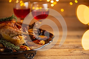 The festive thanksgiving dinner with traditional turkey on the plate and two glasses red wine isolated on wooden background with