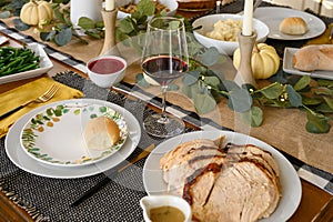 Festive Thanksgiving holiday dinner table with sliced turkey and red wine