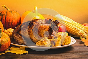 Festive turkey or chicken baked by Thanksgiving a white plate and a harvest of seasonal vegetables: pumpkin corn apples