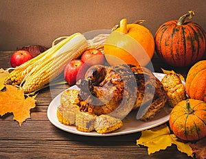 Festive turkey or chicken baked by Thanksgiving a white plate and a harvest of seasonal vegetables: pumpkin corn apples