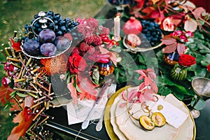 The festive wedding table with red autumn leaves. Wedding decoration. Artwork