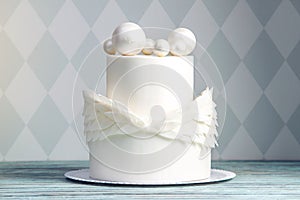 Festive white cake decorated with wings of mastic and chocolate balls on top. Concept ideas desserts for kids