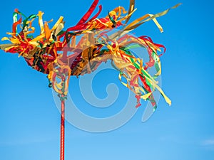 Festive Wooden Pole for Climb on Maslenitsa. Bright ribbons fluttering in the wind