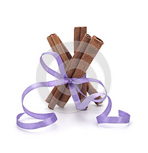 Festive wrapped cinnamon sticks isolated on white background