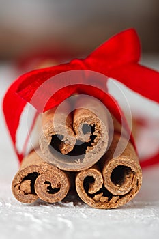 Festive wrapped cinnamon sticks with red ribbon