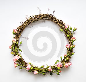 Festive wreath of vines with decorative roses, leaves. Flat lay, top view