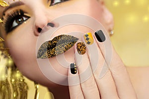 Festive yellow black manicure and makeup .