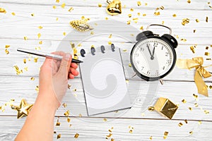 Festivedecorations and notebook with wish list and alarm  on white rustic table, flat lay style. Planning concept. Image