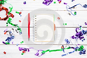 Festivedecorations and notebook with wish list on white rustic table, flat lay style. Planning concept.- Image