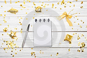 Festivedecorations and notebook with wish list on white rustic table, flat lay style. Planning concept.- Image