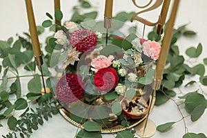 Festively decorated banquet table in the restaurant. Fresh flowers are golden candles and red chairs and garnet. expensively rich